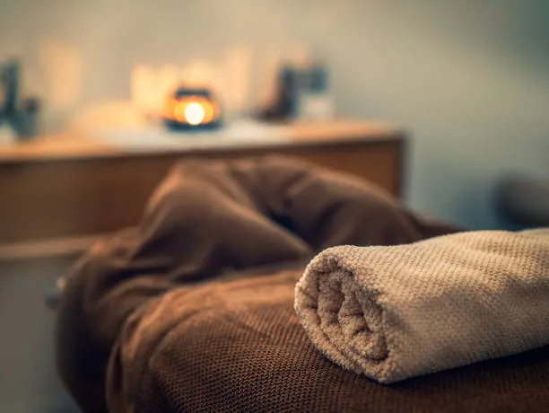 Serviette roulée et bougie : ambiance douce pour un moment de détente