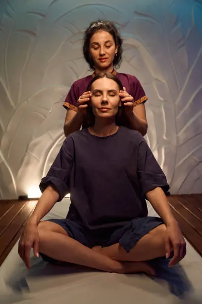 Massage relaxant de la tête et des épaules sur futon
